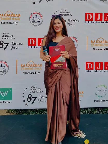 Holding the event brochure at the Delhi Jewellers Association meet. I always come prepared and fully briefed on the event agenda.