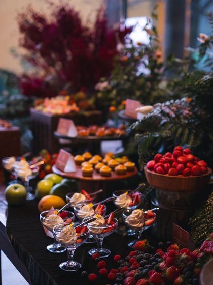 A close-up on the dessert section of our grazing table. We offer a variety of sweet treats, including fresh berries, fruit trifles in elegant glasses, and assorted pastries.