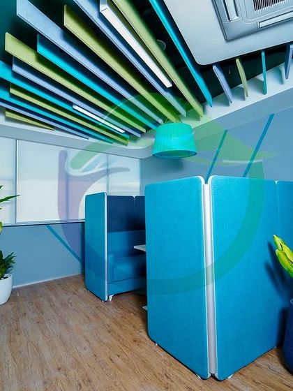 A before-and-after edit showing how a simple change in color palette can affect the mood. Here, we placed tall plants in white planters to soften a corner with blue privacy booths, adding a natural touch to the modern office furniture.