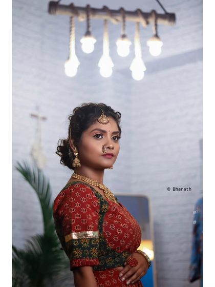 A wider shot that includes the modern interior and lighting, contrasting with the traditional dress.