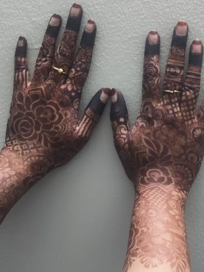 A close-up of the stain on the back of the hands. The floral patterns have developed into a beautiful deep brown, showing the quality of the organic henna.