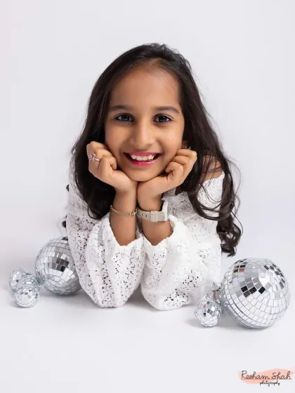 A radiant smile for her 10th birthday. The disco balls add a touch of sparkle and fun to this milestone portrait session.