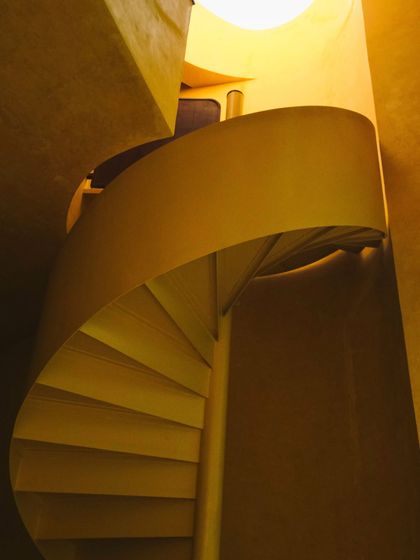 The spiral staircase in the Banyan Suite, a beautiful architectural element that connects the different levels of the space.