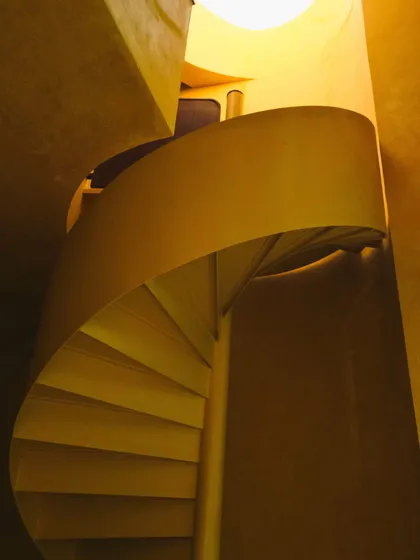 The spiral staircase in the Banyan Suite, a beautiful architectural element that connects the different levels of the space.