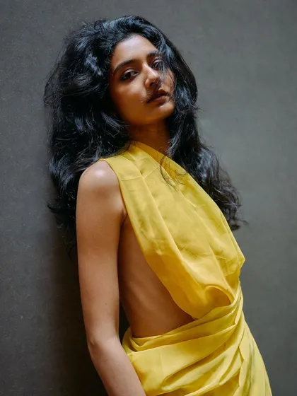A close-up from the yellow drape series. The soft lighting and the model's direct gaze create an intimate and powerful portrait.