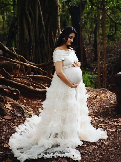 This white ruffled maternity gown looks absolutely magical in a forest setting. The layers of tulle create a soft, cloud-like effect around the mom-to-be.