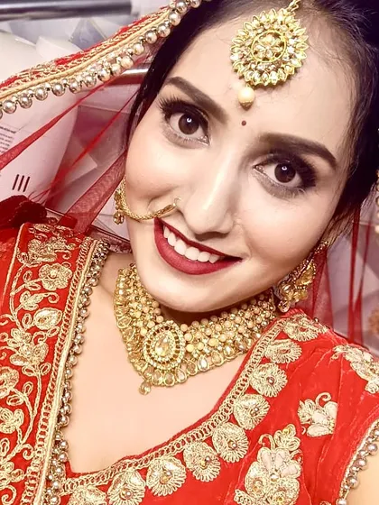 The best part of my job is seeing a bride's happy smile. This close-up shows her radiant skin and joyful expression, a perfect example of a classic red bridal makeup look.