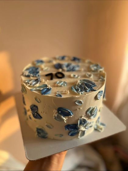 The 70th birthday cake in beautiful evening light, highlighting the texture of the buttercream flowers.