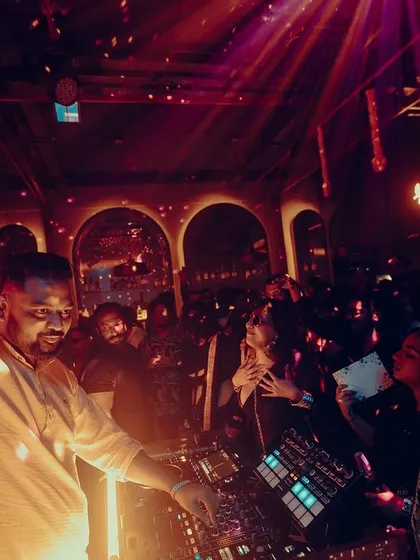 Arm raised, feeling the energy of the room. A great DJ set is a conversation between me and the dancefloor.