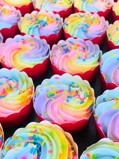 A tight shot of our rainbow cupcakes, showing the soft texture of the frosting and the bright, happy colors.
