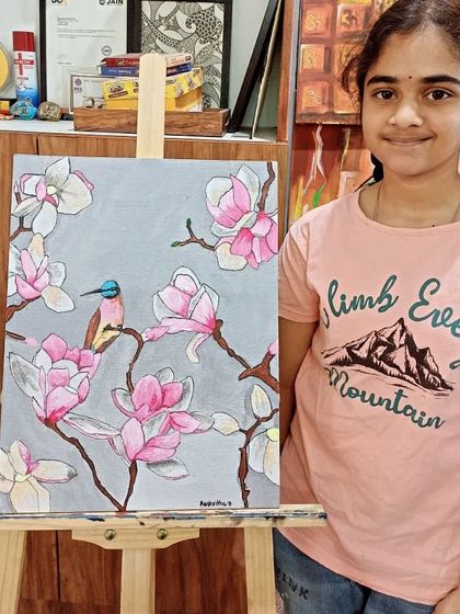 A young artist from my teens' fine art course proudly displays her finished painting of a bird among magnolia blossoms. This piece combines detailed line work with soft acrylic coloring.