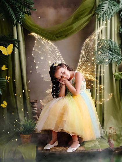 The cutest little fairy, with rainbow wings and a gentle expression, resting in a magical green forest.