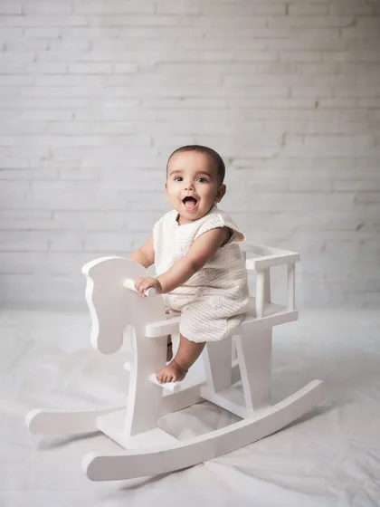 Sometimes, the simplest moments are the most precious. For this classic baby portrait, I used a clean, white backdrop and a simple rocking horse to keep the focus entirely on the baby's bright, happy expression. It’s a pure and timeless way to remember this sweet stage.