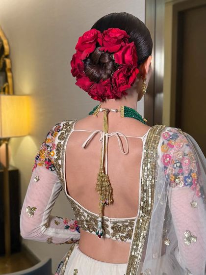 The back view of the sleek bun with a full crown of red roses, a truly statement bridal hairstyle.