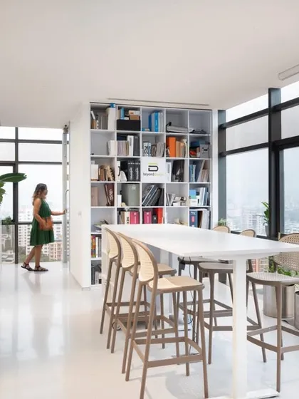 Our office library and material resource center, with a high table for quick meetings or individual work. The large windows provide ample natural light and a connection to the outdoors.