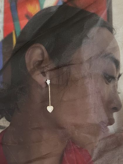 An artistic shot of our delicate heart-shaped droplet earring, showcasing its subtle sparkle and romantic design.