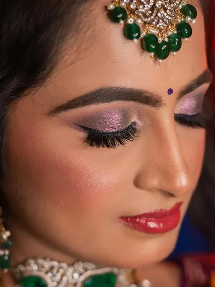 A close-up on the details of this stunning reception look. I created a shimmery, lavender-toned smokey eye with a sharp winged liner and full lashes to make her eyes pop. Paired with a glossy red lip, this makeup is perfect for an evening of celebration and photographs beautifully under any lighting.