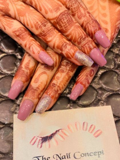 A simple and elegant look for bridal or festive occasions. The mauve-colored nails are paired with silver glitter accent nails that complement the henna design.