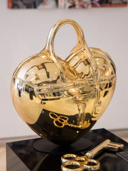 The "Birkin Love Sculpture" in gleaming gold chrome. This piece embodies love and luxury, with the iconic Birkin silhouette transformed into a heart, complete with a key to unlock it.