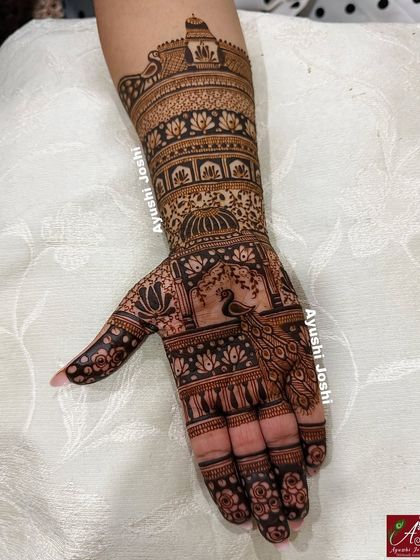A gorgeous design perfect for Teej or Karva Chauth, featuring a peacock in a jharokha and intricate patterns up the arm.