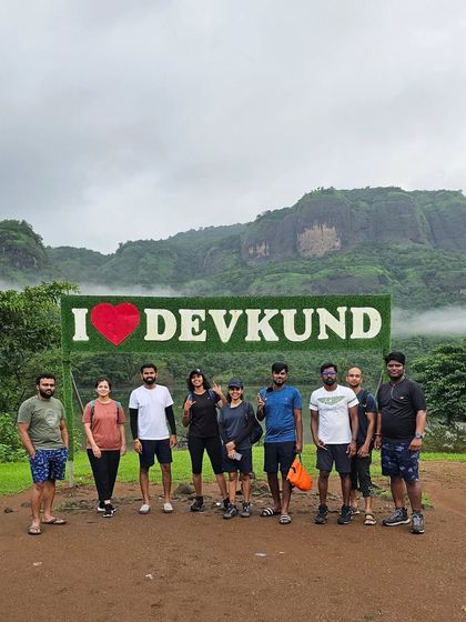 The group posing with the "I Love Devkund" sign after a rewarding trek to the famous waterfall.