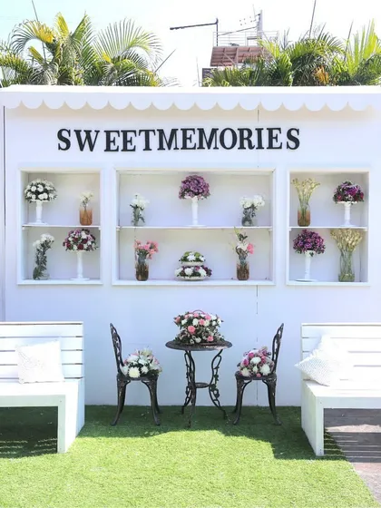 A 'Sweet Memories' photo station with a clean, white, European-inspired design, offering a charming backdrop for guests to capture moments.