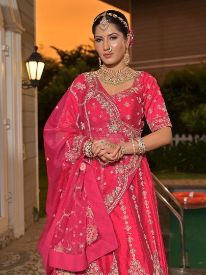 A complete bridal look featuring a heavy, gold-plated Kundan necklace, haath phool, and maang tikka, all available for rent.