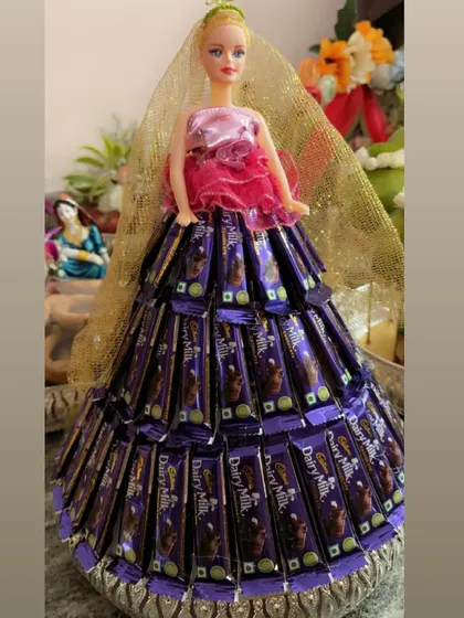 A fun and delicious gift idea we brought to life for a celebration. This doll features a custom-made gown created entirely from Cadbury Dairy Milk chocolate bars, making for a memorable and sweet surprise.
