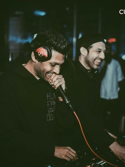 Two DJs laughing and enjoying the moment behind the decks. The positive energy between the artists is infectious and spreads directly to the dance floor.