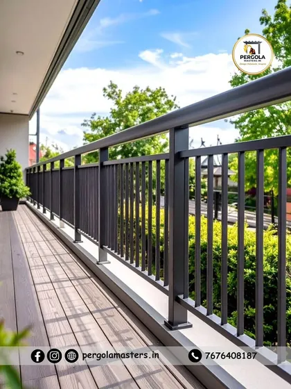 A long expanse of modern black railing secures a spacious terrace with a wooden deck. The simple vertical design ensures safety without obstructing the view of the lush green surroundings, making it perfect for enjoying the outdoors.