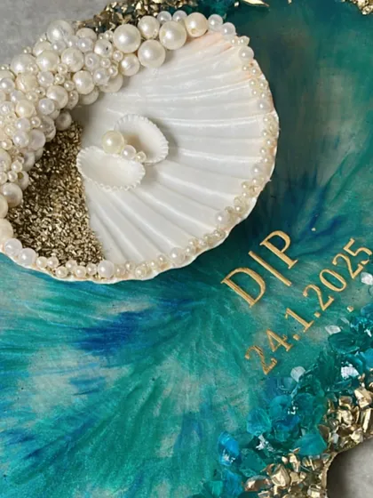 A detailed shot of the seashell ring holder, adorned with pearls and set on a beautiful teal and gold resin tray.