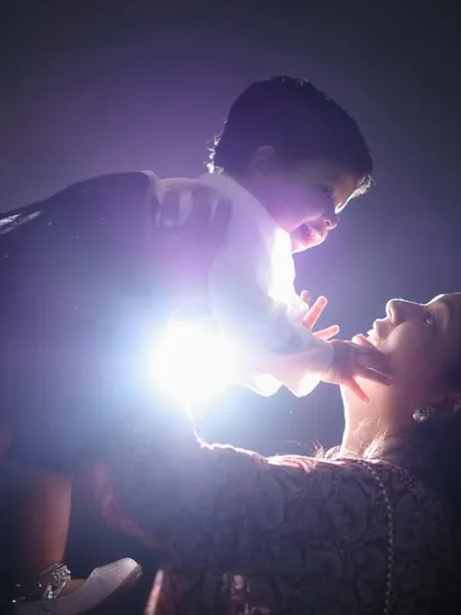 A powerful and emotional silhouette of a mother lifting her child, with a bright light creating a starburst effect. This is a truly artistic family portrait.