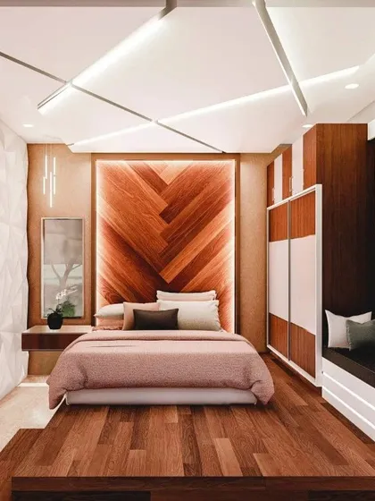 A bedroom should be your personal sanctuary. This design for a client in Mysore features a backlit herringbone wood accent wall, a custom 3D panel wall, and a modern false ceiling design to create a luxurious and calming atmosphere.