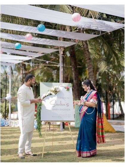 The happy couple arriving at their baby shower. This shot captures the scale of the outdoor venue and the festive atmosphere created by the decorations.