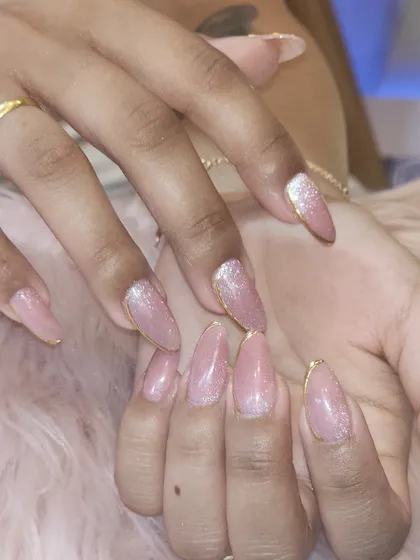 A beautiful example of a glittery pink manicure with a delicate gold chrome outline. This design is perfect for adding a touch of sparkle to your everyday look.