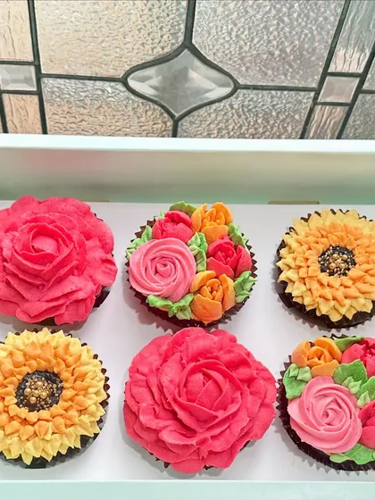 A beautiful box of six hand-piped floral cupcakes ready to make someone's day. This set features a mix of vibrant buttercream roses and sunflowers on our classic chocolate cupcakes, perfect for birthdays, thank you gifts, or just because.