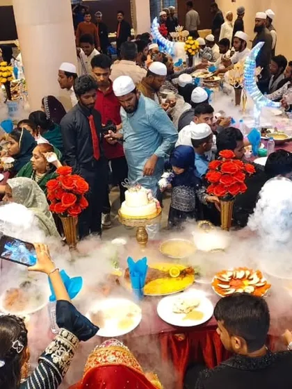 An overhead view of the celebration. Guests capture the moment as the dry ice smoke cascades over the table, creating a magical, cloud-like effect.