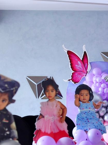Life-sized photo cutouts of the birthday children, adding a highly personal touch to this butterfly-themed party decor.