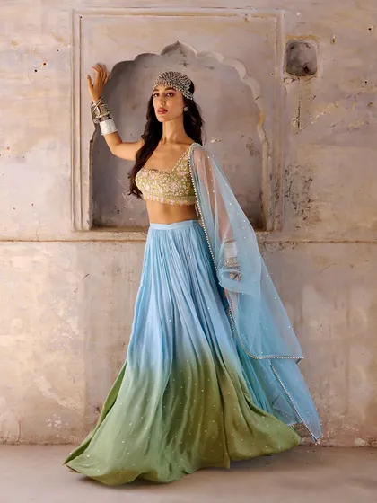 This ombre blue and green lehenga from the Anam Cara collection is inspired by the beauty of nature. The embellished blouse and bohemian styling make it a unique and stunning choice.