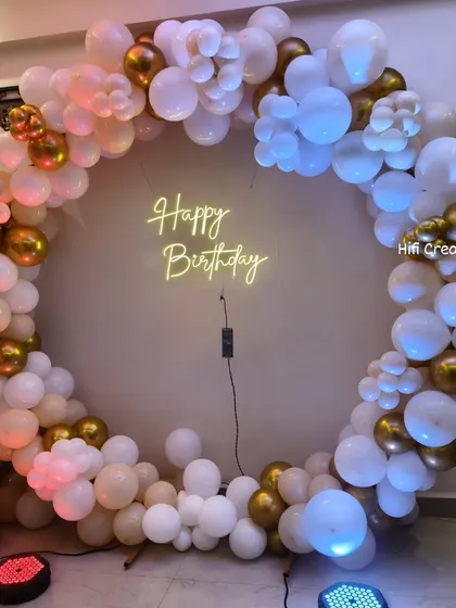 This circular balloon backdrop is one of my most popular designs for birthdays and anniversaries. I use a mix of white, nude, and chrome gold balloons to create a sophisticated frame, centered around a warm "Happy Birthday" neon sign that sets a celebratory mood.