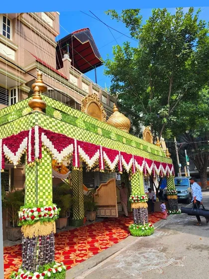 A grand chappara with red and white flower hangings, set up for a wedding. You will learn how to design and execute these large, traditional structures.