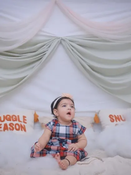 A little girl sitting in a dreamy "Snuggle Season" setup, looking up in awe. We create imaginative scenes for our indoor photoshoots.