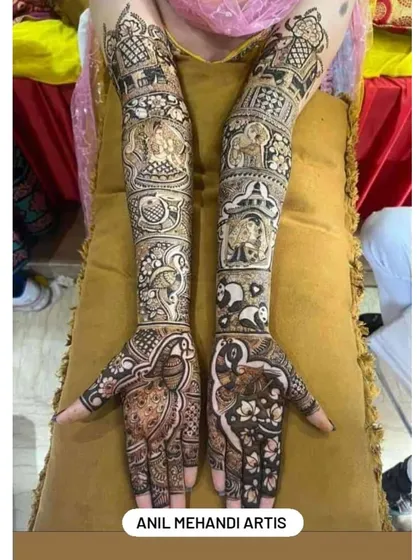 This intricate bridal design is filled with symbolic figures. It includes elephants, pandas, peacocks, and other motifs, creating a rich tapestry of art that extends from the fingers to the elbows.