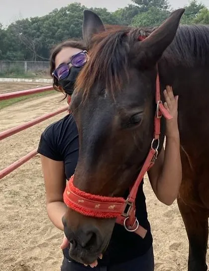 A rider shares a moment of affection with her horse. We teach our students that partnership and care are just as important as performance in the dressage arena.