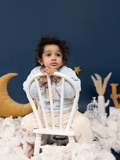 A thoughtful moment among the moon and stars. This portrait showcases our dreamy celestial theme, perfect for capturing the wonder and imagination of childhood.
