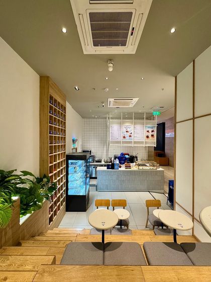 Looking down from the top of the stepped seating at Beanly. This perspective highlights the different levels and how the space is designed for both individual lounging and small group interactions, next to the prominent product display.