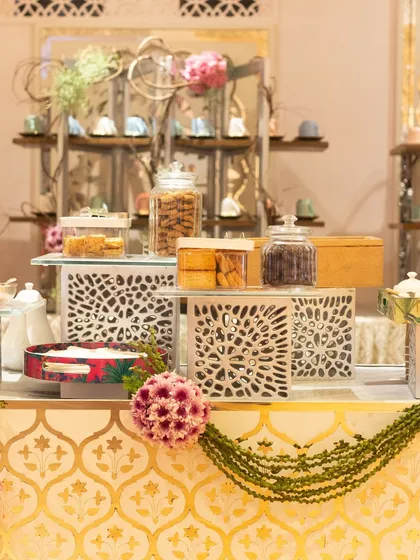 A full view of our high-tea station, complete with glass jars of assorted cookies and biscuits, and elegant serving ware. It’s a comprehensive setup for a sophisticated tea break.
