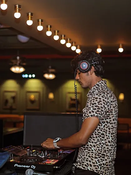A side profile of me at the decks, with the warm club lighting in the background.