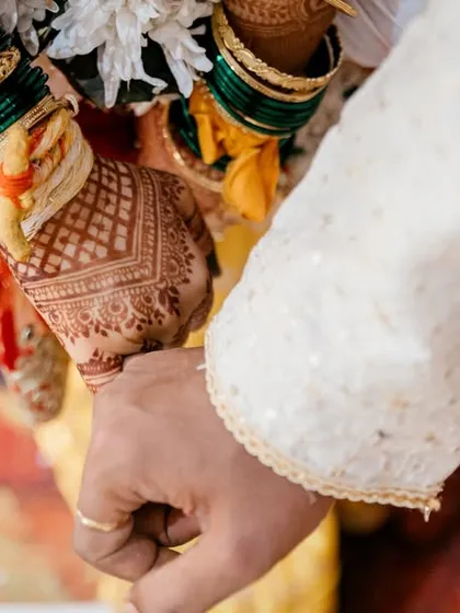 A close-up of the couple holding hands, a simple yet powerful symbol of their union.