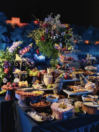 A lavish charcuterie and grazing table, artfully arranged and adorned with florals, showcasing that every detail, including the food display, is part of the design story.